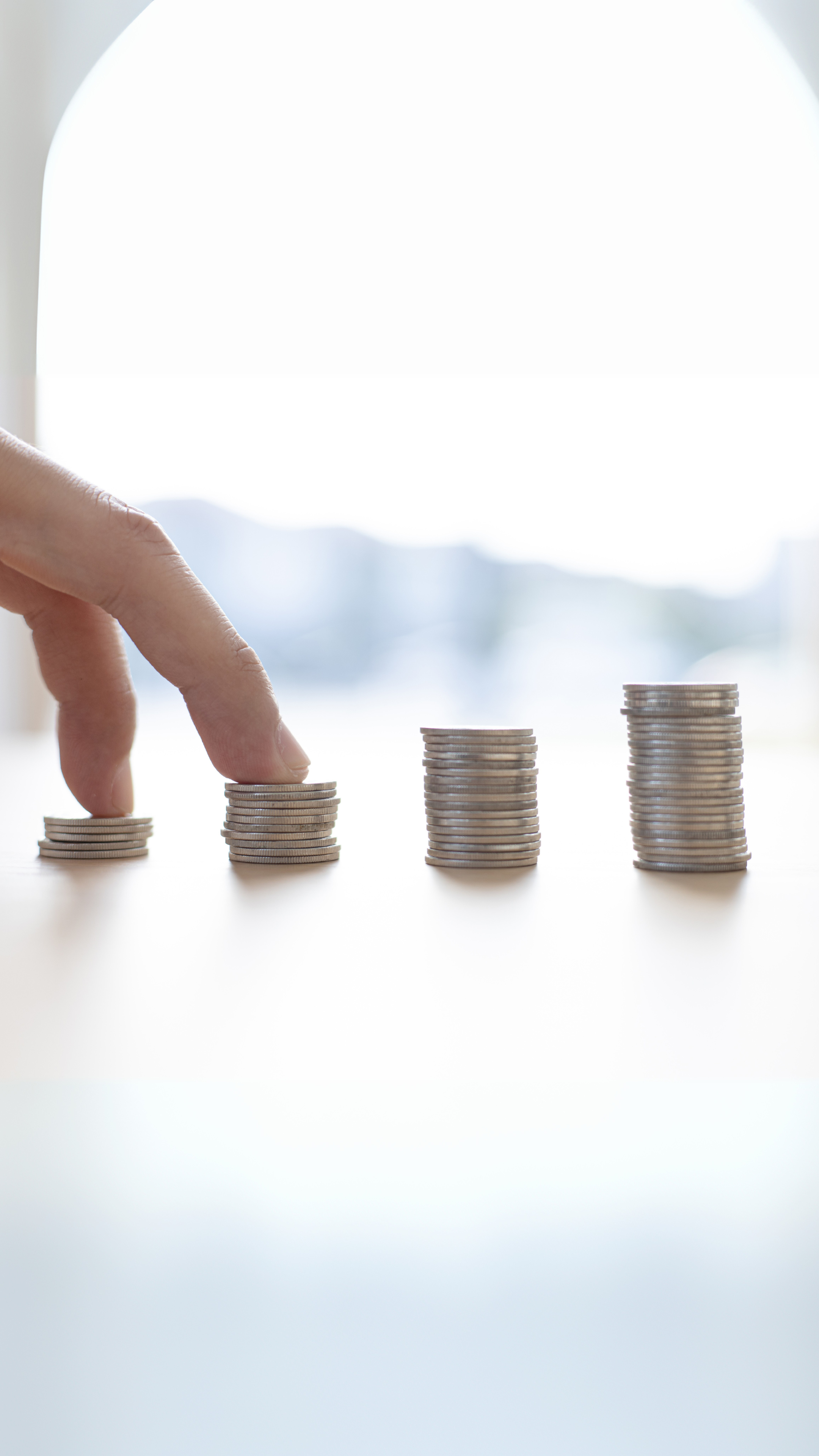 Pessoa a subir degraus de moedas, simbolizando o progresso financeiro passo a passo